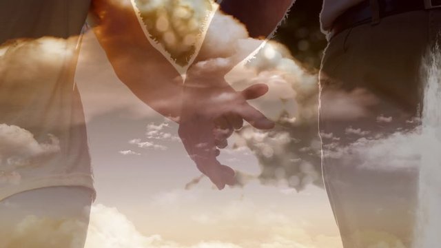 Animation of a Christian cross over a couple holding hands 