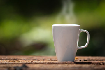 Fototapeta na wymiar Coffee cup on natural blurred background outdoor