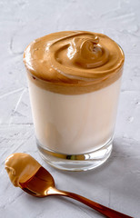 Dalgona Coffee. Milk topped with whipped instant coffee.