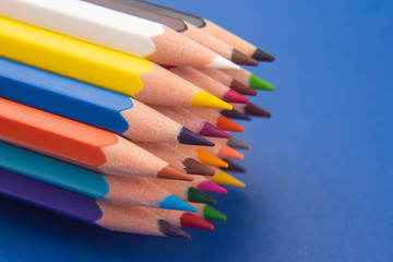 Fototapeta premium set of color pencils on a blue background. drawing tools. a palette in creativity