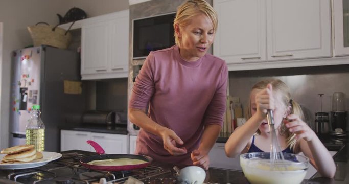 Side view of Caucasian woman cooking with her daughter at home