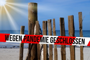Ein Strand und Absperrband mit dem Hinweis Wegen Pandemie Geschlossen