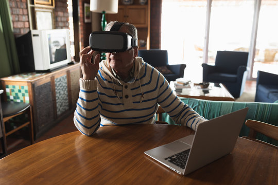 Senior man using virtual reality headset at home