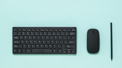 Keyboard, mouse and black pencil on a light background.