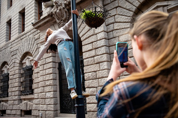 Rear view of girl taking her friend in photo