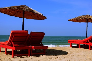 beach chairs and umbrella on isolated beach