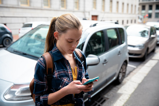 Side view of girl using her phone outside