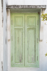 Old green window on classic house wall background.