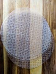Circular rice paper on a wooden background. Used to make spring rolls