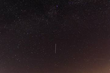 Background of the night sky with many stars. Satellite trajectory