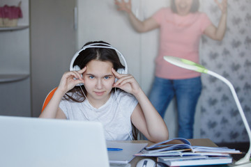 Teenager girl at a table with a white laptop.