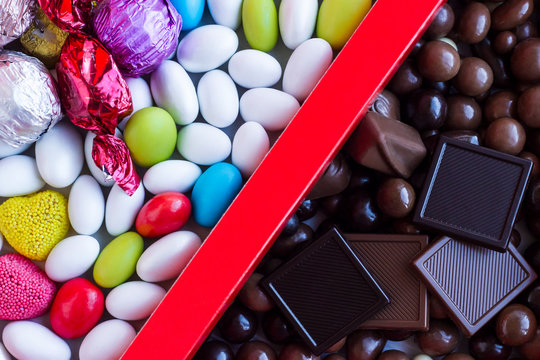 Colorful Almond Candies and Chocolate Madlen in the red color cardboard box.Looking devided in two.The Sugar Feast or any feast concept.