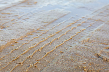 Tracks of car on sand.