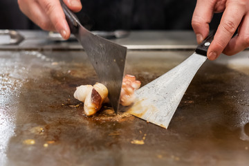 Grilled octopus or cuttlefish on hot plate pan during Teppanyaki Japanese Chef cooking and grilling in restaurant. Delicious and Popular for tourists attractions in Kobe district, Hyogo, Japan