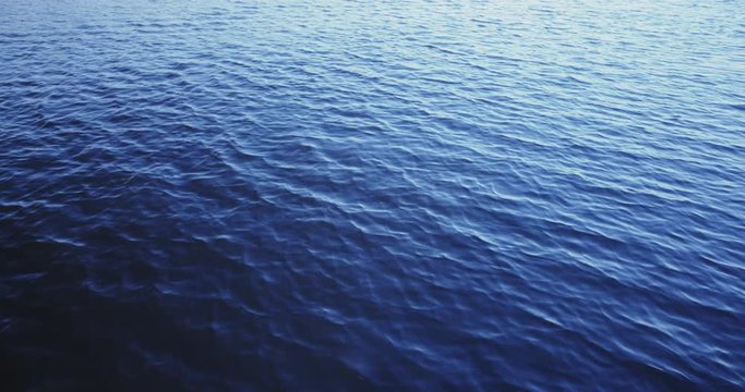 Slow motion shot of water ripples over a river or a lake.