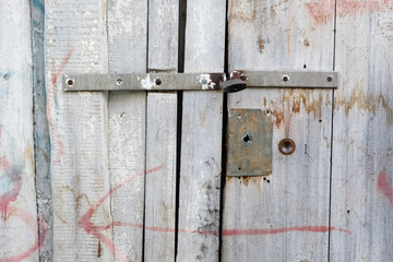 The shed, wooden door decay sample in close up view with metal padlock