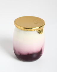 Yogurt with jam in small glass jar with aluminium foil seal cap.