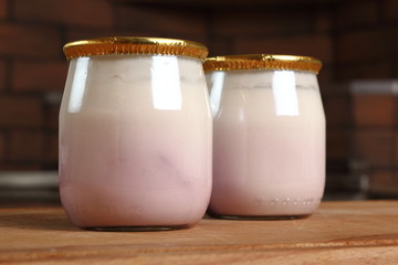 Yogurt in small glass jar with aluminium foil seal cap