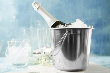 Bucket with ice and champagne on color background © Pixel-Shot