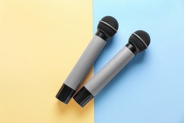 Modern microphones on color background
