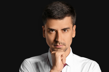 Portrait of handsome businessman on dark background