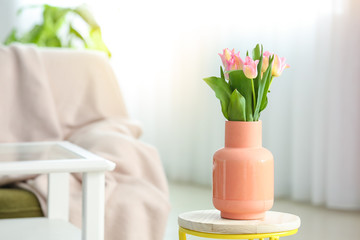 Stylish vase with tulip flowers in interior of living room