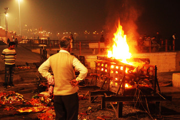People look at the funeral pyre that night. The ceremony of the cremation of Manikarnika Ghat on...