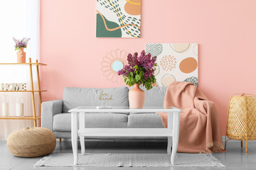 Beautiful lilac flowers on table in living room