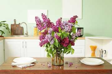 Beautiful lilac flowers on table in kitchen