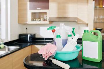 Basin with various cleaning sprays, detergents and big package of desinfectant