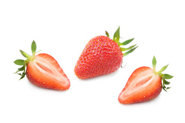Ripe fresh organic strawberry and two halves of a strawberry with leaves isolated on a white background