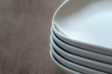 Stack pile of rectangular white ceramic dishes with rounded edges. .