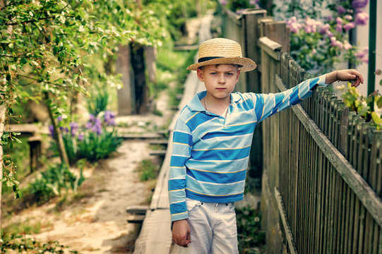 Portrait of a boy in a straw hat in the countryside
