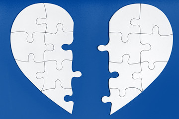 Two matching halves of one heart on trendy blue. Care, health, support, love concept. Separation,...