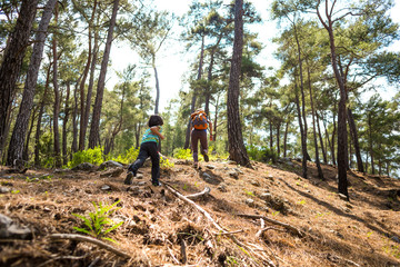 A woman runs with a child on a forest road.