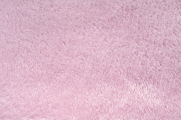 Fluffy pink synthetic fabric background. Soft plush pastel textile texture of winter clothing