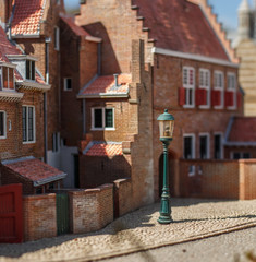 old street, red brick house and a lantern in miniature photographed with blur. 