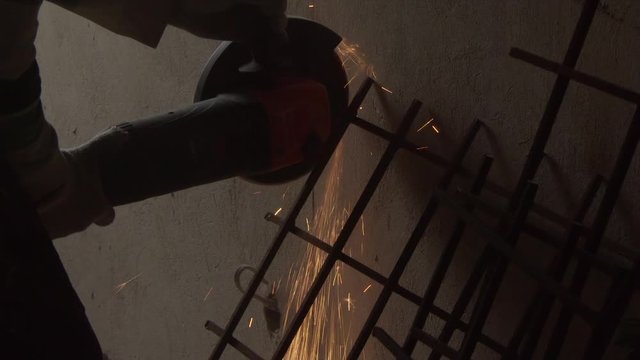 Cutting steel with angle grinder in workshop