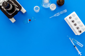 Microscope medical reserch. Blood sample for analysis. Blue table top view copy space