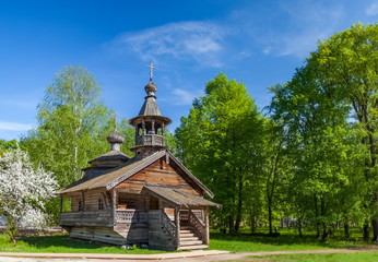 Fototapeta na wymiar Wooden Church in the forest in summer against the sky