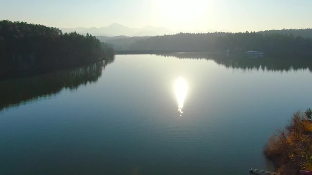 Cinematic fly over calm water of Smartinsko lake. Artificial lake, Slovenia