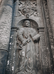 Saint Peter with key of paradise and book Bible. An architectural element under the bas-relief of the Boim Chapel. Old carving on the surface of alabaster. Lviv, Ukraine.