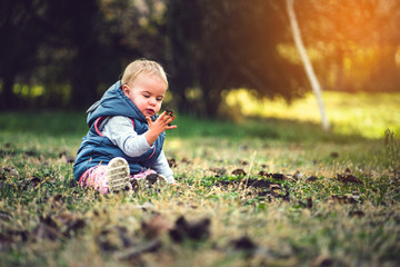 Toddler playing in grass and mud. Dirty hands, nature and immunity concept.