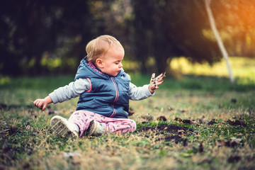 Toddler playing in grass and mud. Dirty hands, nature and immunity concept.