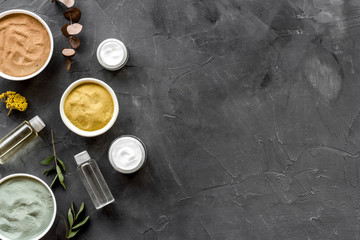 Set of cosmetic clays for facial beauty face mask on black table top-down frame space for text