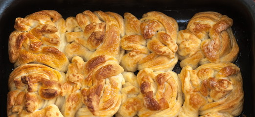 Ready-made sweet buns closeup on the baking sheet