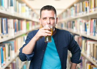Young man wearing a blue outfit. Drinking beer.