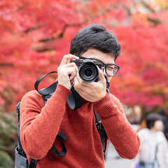 Happy man traveler taking photo colorful leaves in the garden, Asian tourist visit in Kyoto city,...