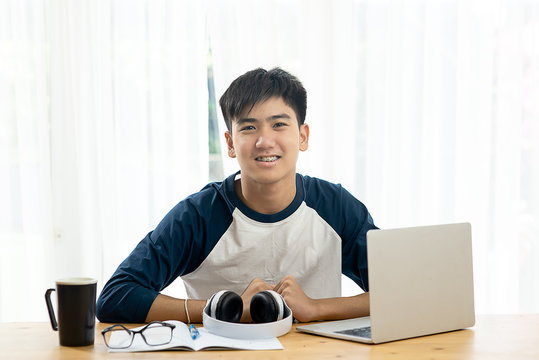 Asian teenager using laptop for home schooling concept during corona virus.