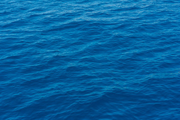 A close up of the deep and pristine blue Mediterranean sea on a sunny day, in Sardinia Italy